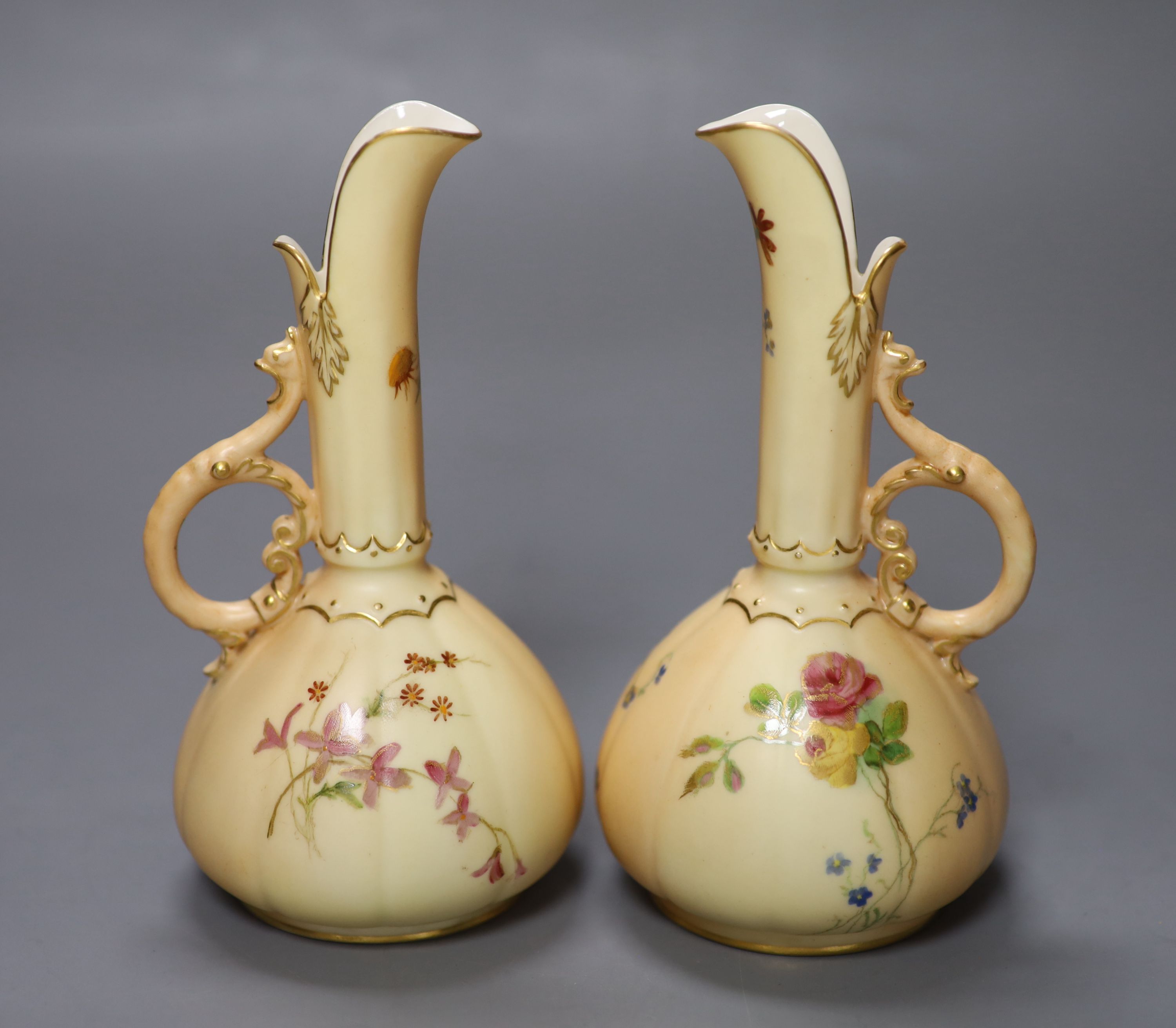 A pair of Royal Worcester blush ivory ewers painted and gilded with flowers, green mark, date code 1900, height 15cm